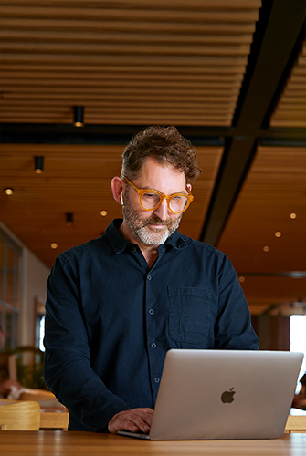 Una persona del equipo Corporativo de Apple usando una MacBook en un Caffè Macs.