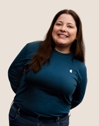 Portrait of a smiling Apple Retail team member with long dark hair.