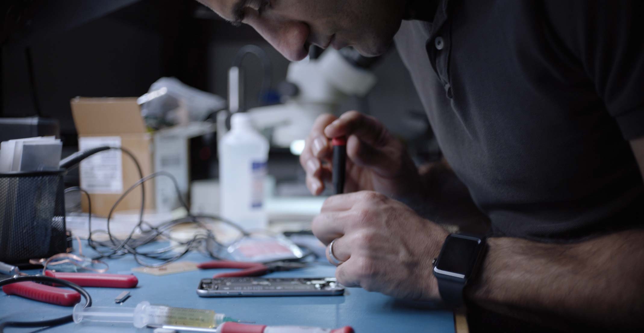 Ehsan, an engineering manager for Apple&rsquo;s Sensing Product Design group, works on an iPhone in an engineering lab.