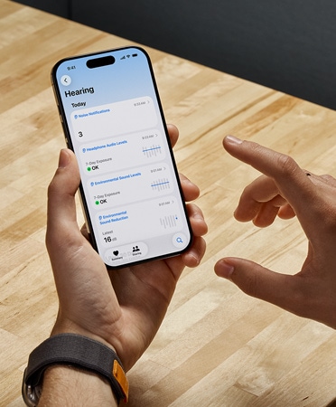 Egy AirPods Pro 2-felhasználó iPhone-t tart a kezében, miközben az új Hallásteszt funkciót használja