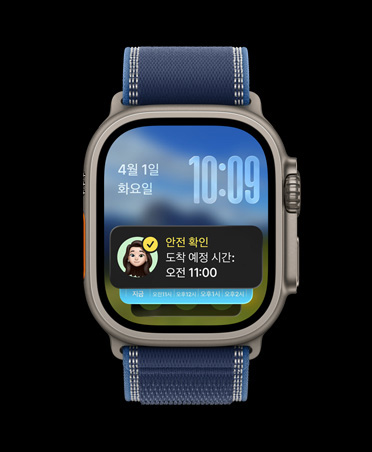 안전 확인 알림이 스마트 스택 위에 추가된 모습이 보이는 블랙 색상 티타늄 케이스의 Apple Watch Ultra 3, 그리고 블루/브라이트 블루 색상 트레일 루프