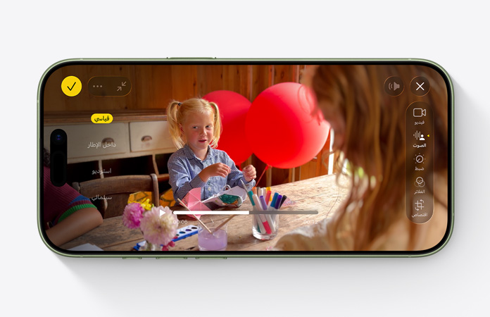 جهاز iPhone 17، الجزء الأمامي الخارجي، فيديو لطفل يلعب بالبالونات على طاولة مع ميزة المزيج الصوتي قيد الاستخدام