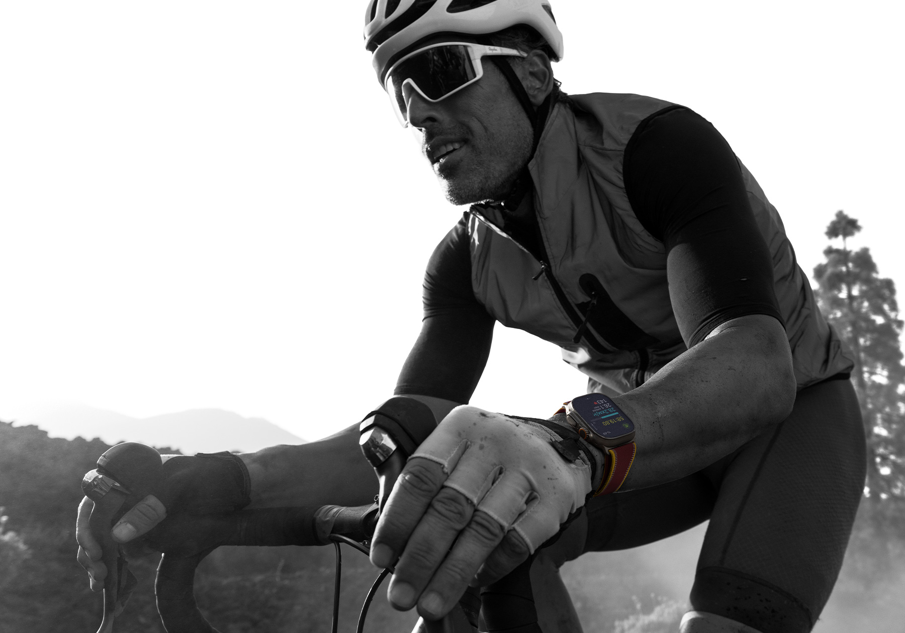 A person riding a road bike while wearing Apple Watch Ultra 4, screen shows cycling metrics