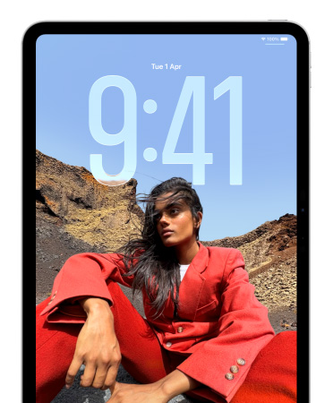 iPad showing Lock Screen where large numerals for the time appear behind the picture of a person sitting