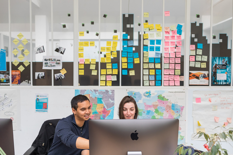Deux personnes travaillant sur un iMac.