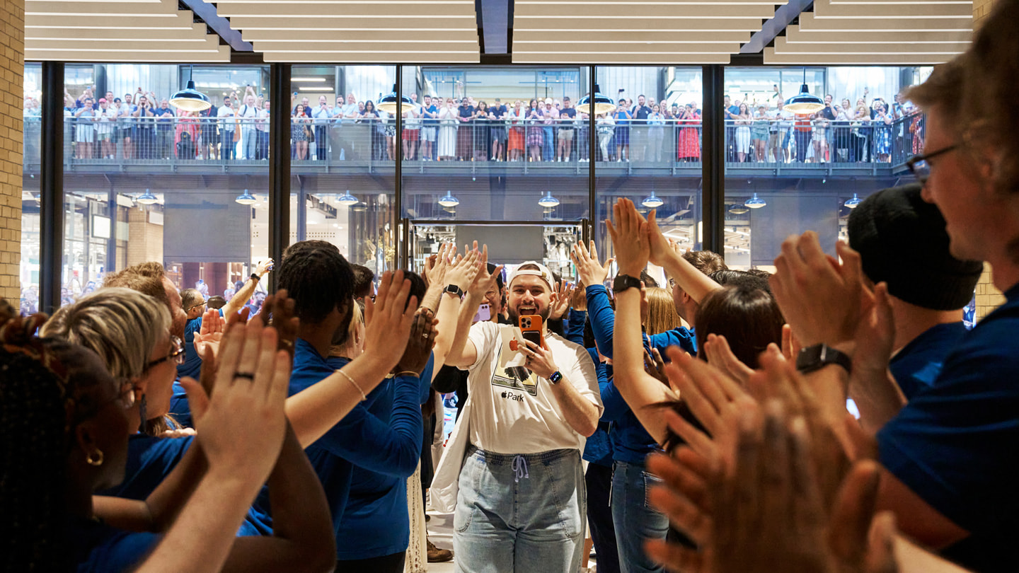 Team members applaud the first visitors to Apple Battersea. 