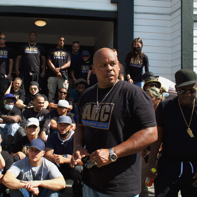 People gather around Sam Lewis for Anti-Recidivism Coalition’s Community Garden Day at Magnolia Transitional Housing. 