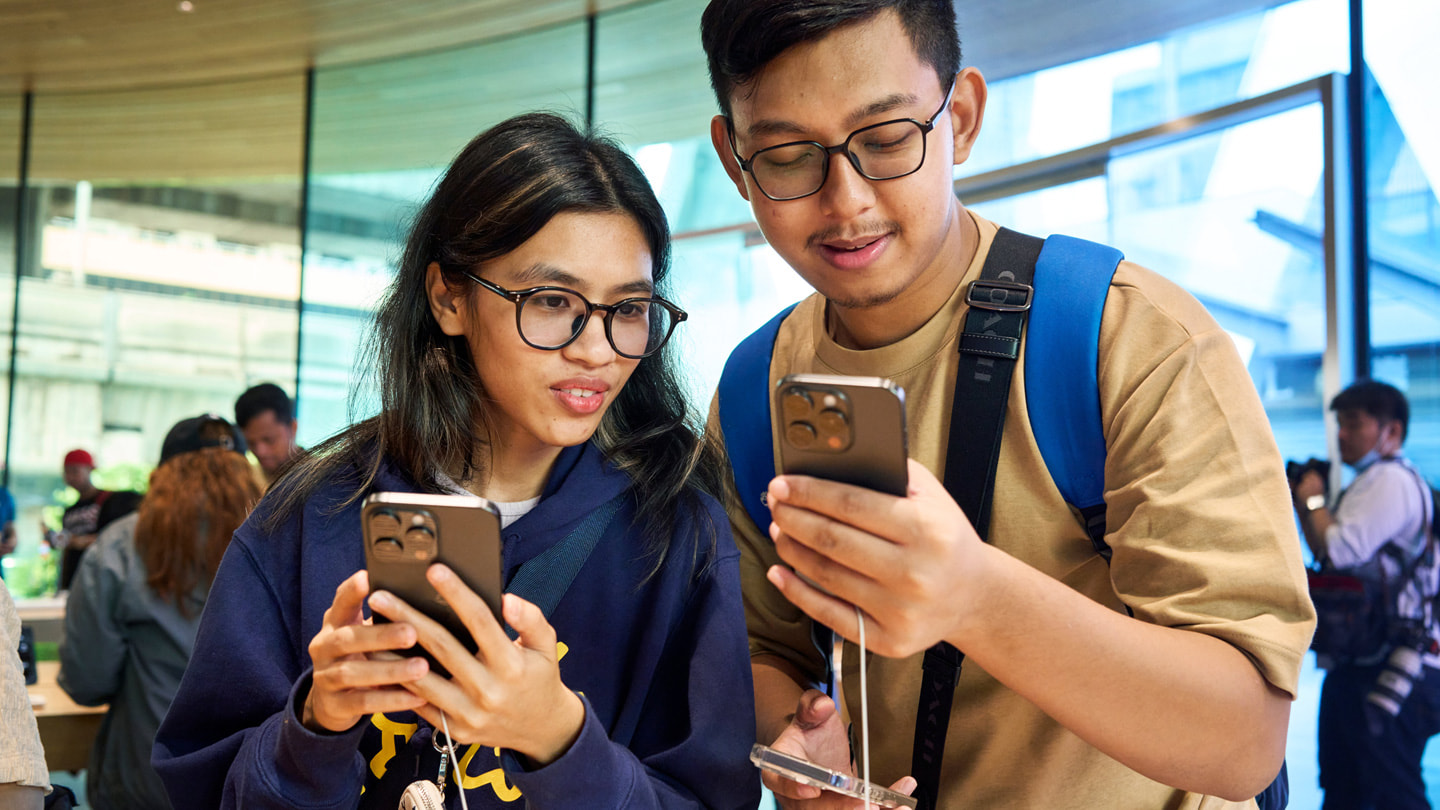 Customers trying out iPhone 15 Pro Max (left) and iPhone 15 Pro (right).