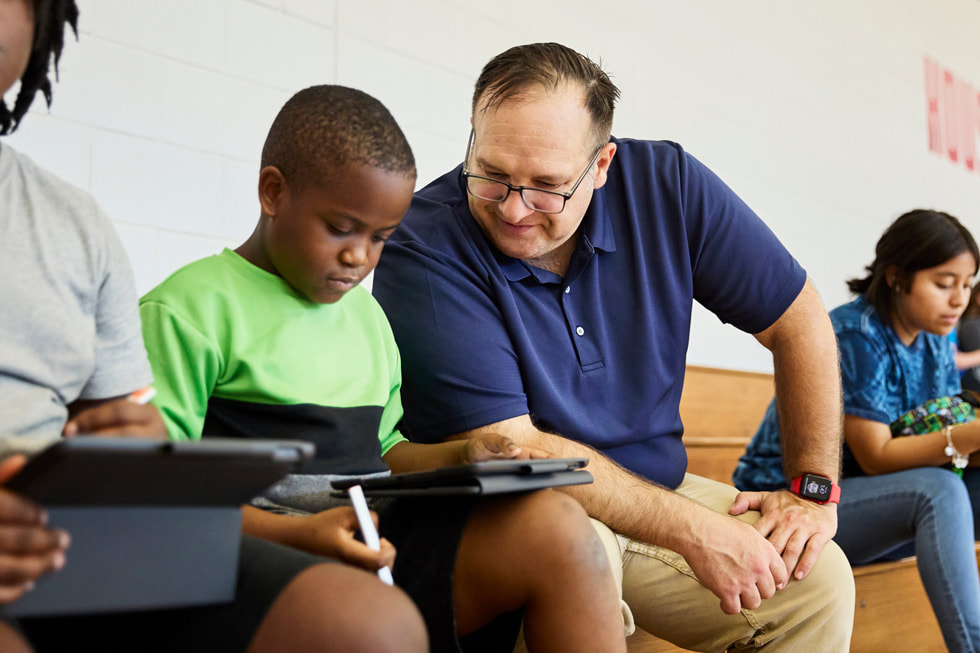 Juan Marquez with a student looking at their work on iPad.