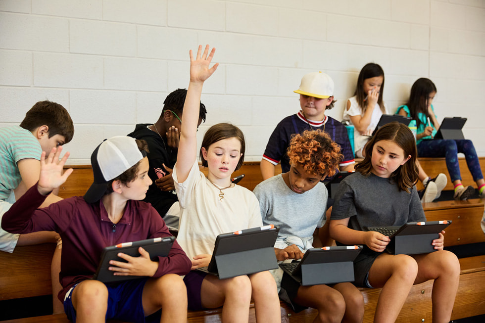 A group of young students raising their hands during the TechConnect event.