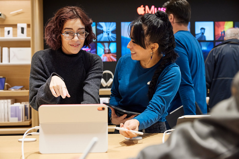 A customer and a team member stand next to the store’s iPad display.
