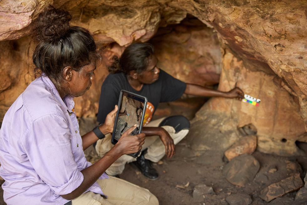 Participants of KKT’s Indigenous women’s ranger programs use iPad in a cave.