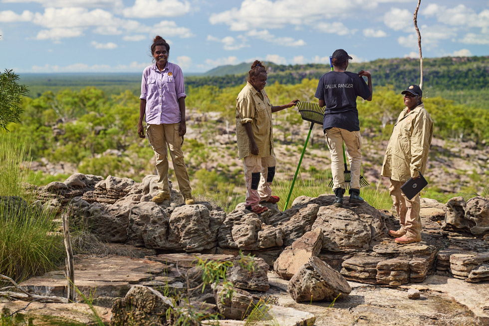 Participants of KKT’s Indigenous women’s ranger programs stand on rocks.