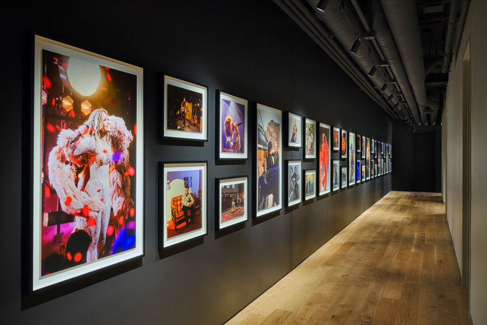 A corridor features framed photos of musicians hanging on the wall.