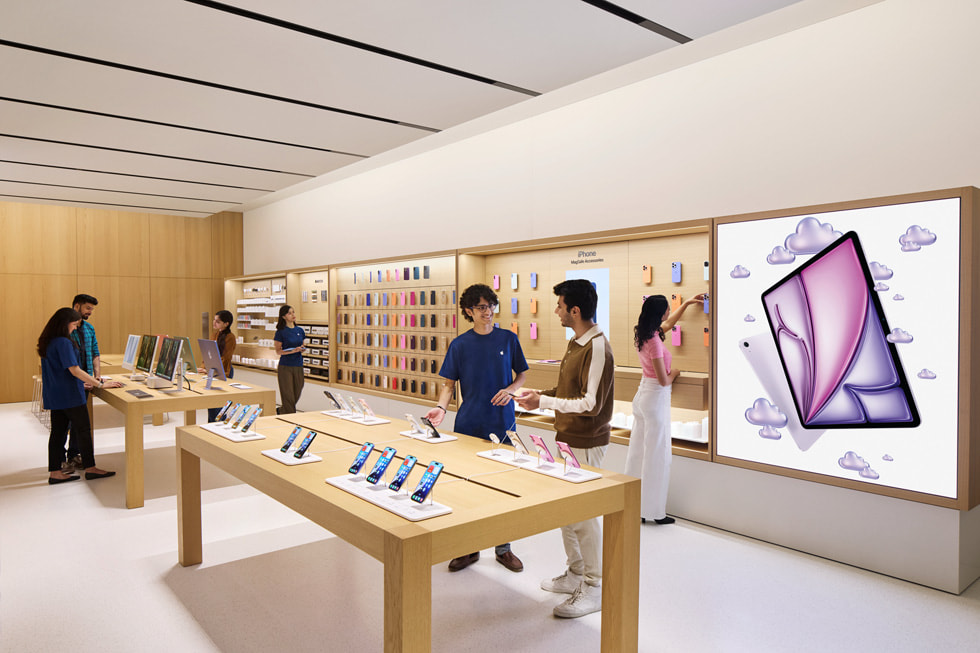 An image of Apple Specialists speaking with customers inside Apple Hebbal.