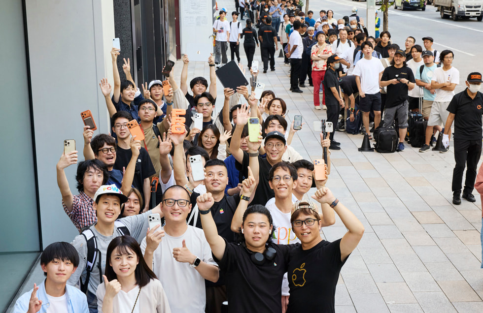 A long line of customers is shown waiting outside Apple Ginza.