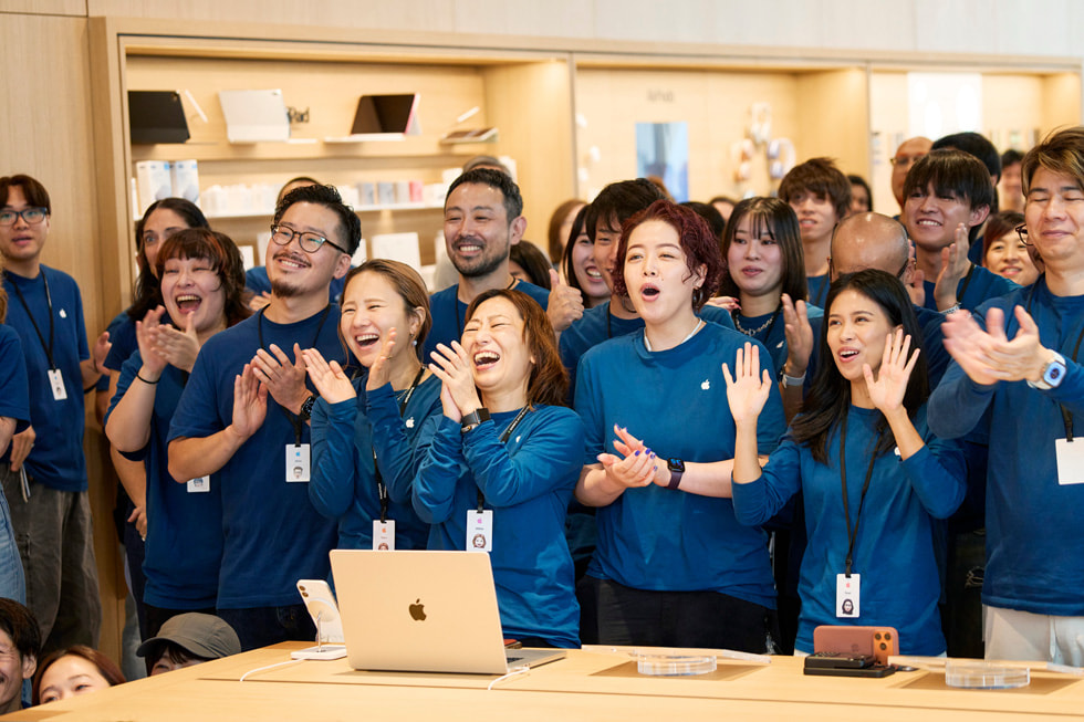 Team members are pictured clapping inside Apple Ginza.