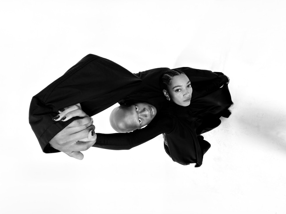 以 iPhone 17 Pro 拍攝的俯視照片，呈現舉起手的兩人。