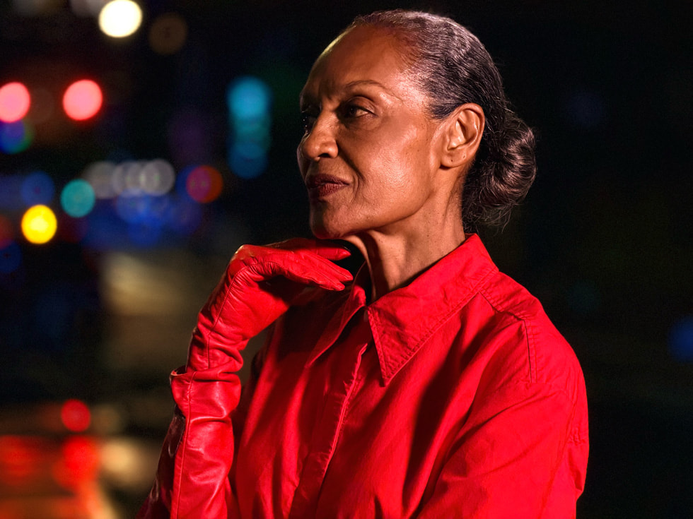 以 iPhone 17 Pro 拍攝的低光源照片，呈現一個人站在夜晚的街道上。