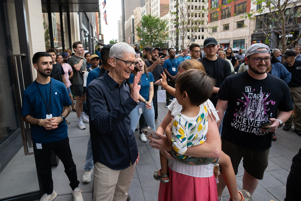 Tim Cook waves at a young customer outside Apple Downtown Detroit.