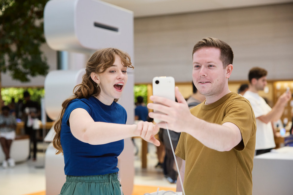 An Apple Fifth Avenue team member helps a customer use iPhone Air.