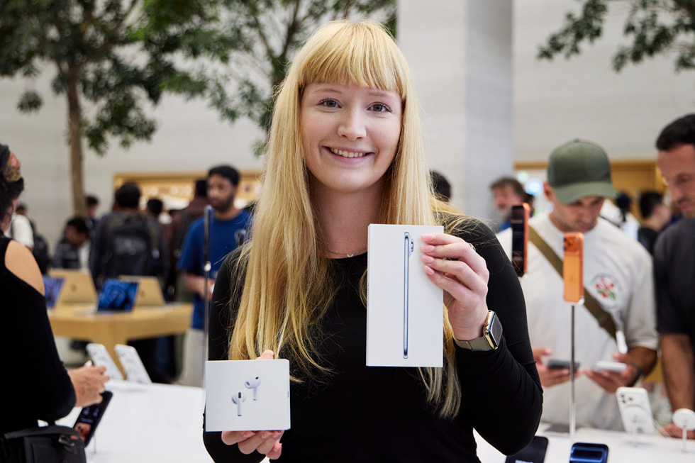 A customer shows off her new sky blue iPhone Air and AirPods Pro 3 at Apple Regent Street in London.