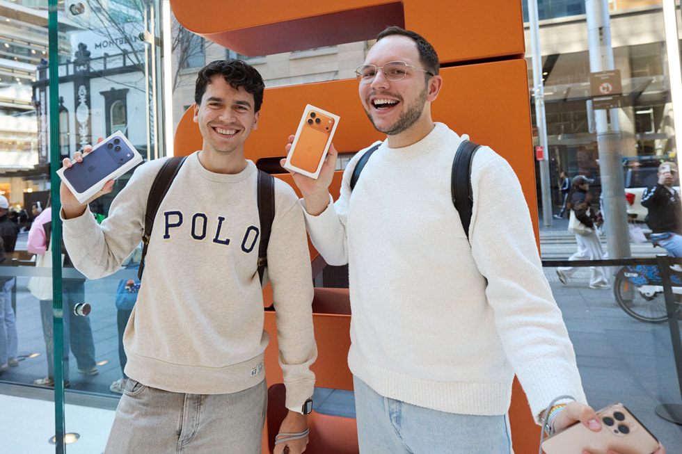 Two smiling customers proudly pose with their iPhone 17 Pro purchases at Apple Sydney in Australia.