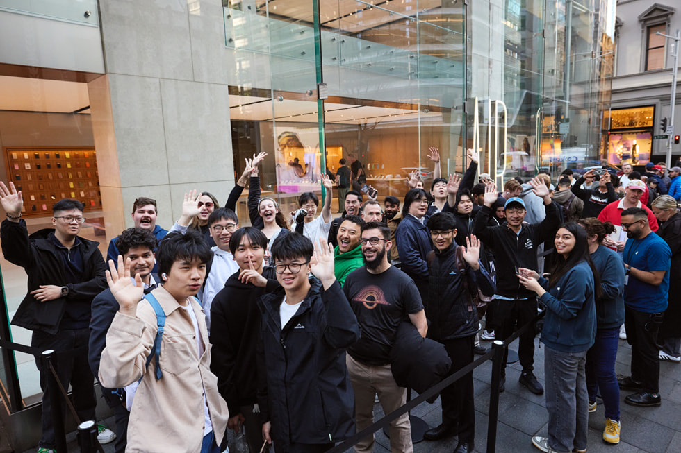 A large group of excited customers stand in line outside the Apple Sydney store in Australia.
