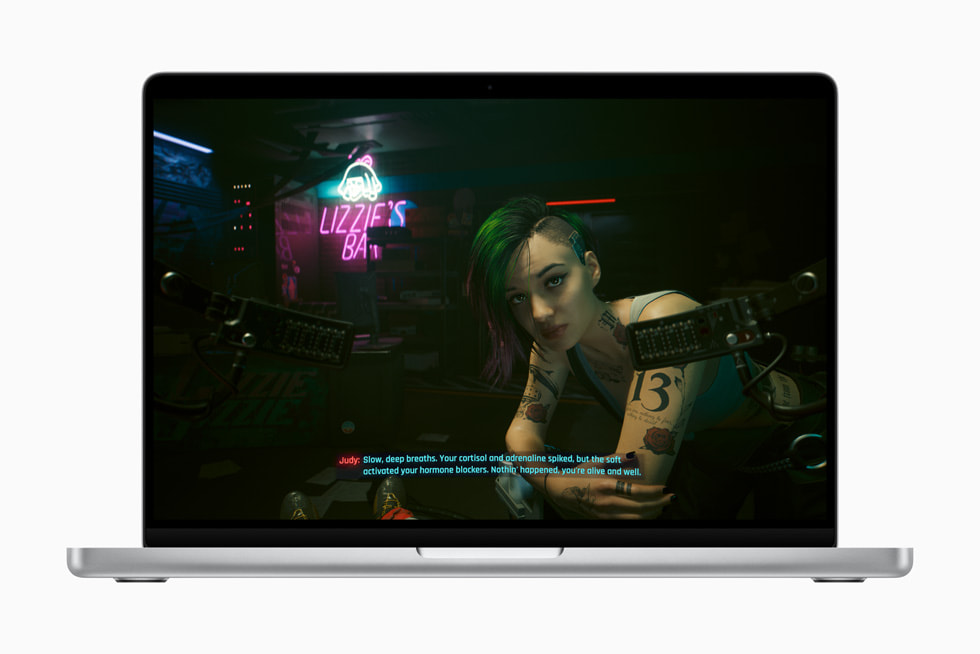 A screenshot from Cyberpunk 2077 that shows a tattooed character named Judy sitting outside Lizzie’s Bar. She says to the player: “Slow, deep breaths. Your cortisol and adrenaline spiked, but the soft activated your hormone blockers. Nothin’ happened. You’re alive and well.”