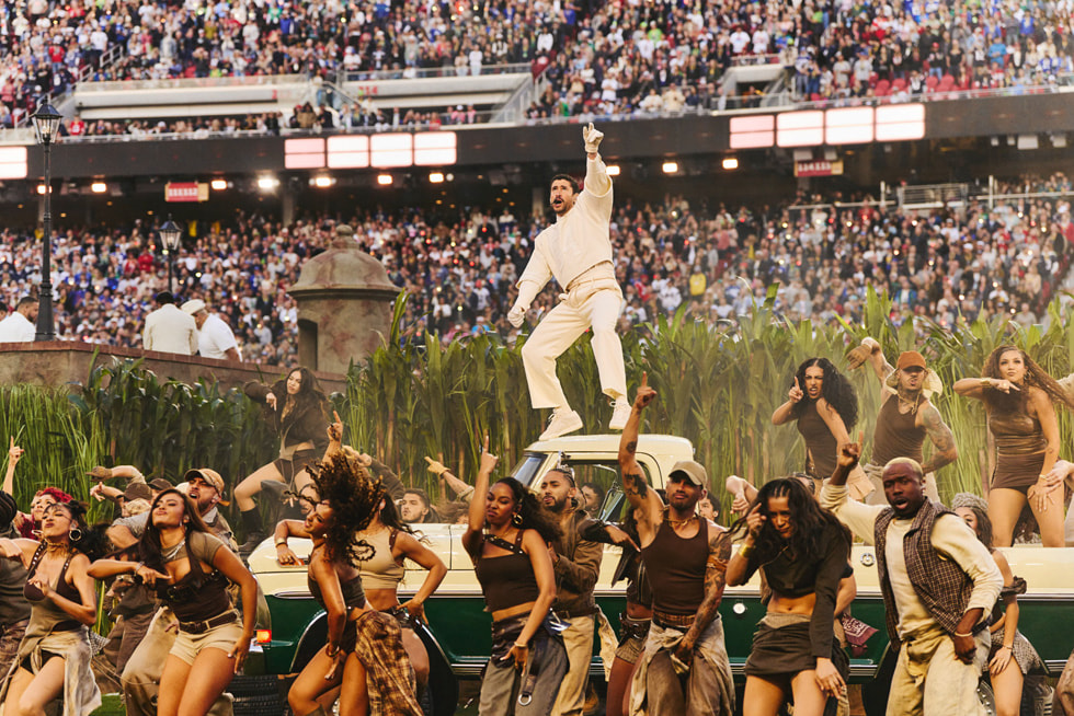 Bad Bunny stands atop a car as he performs at the Apple Music Super Bowl LX Halftime Show.