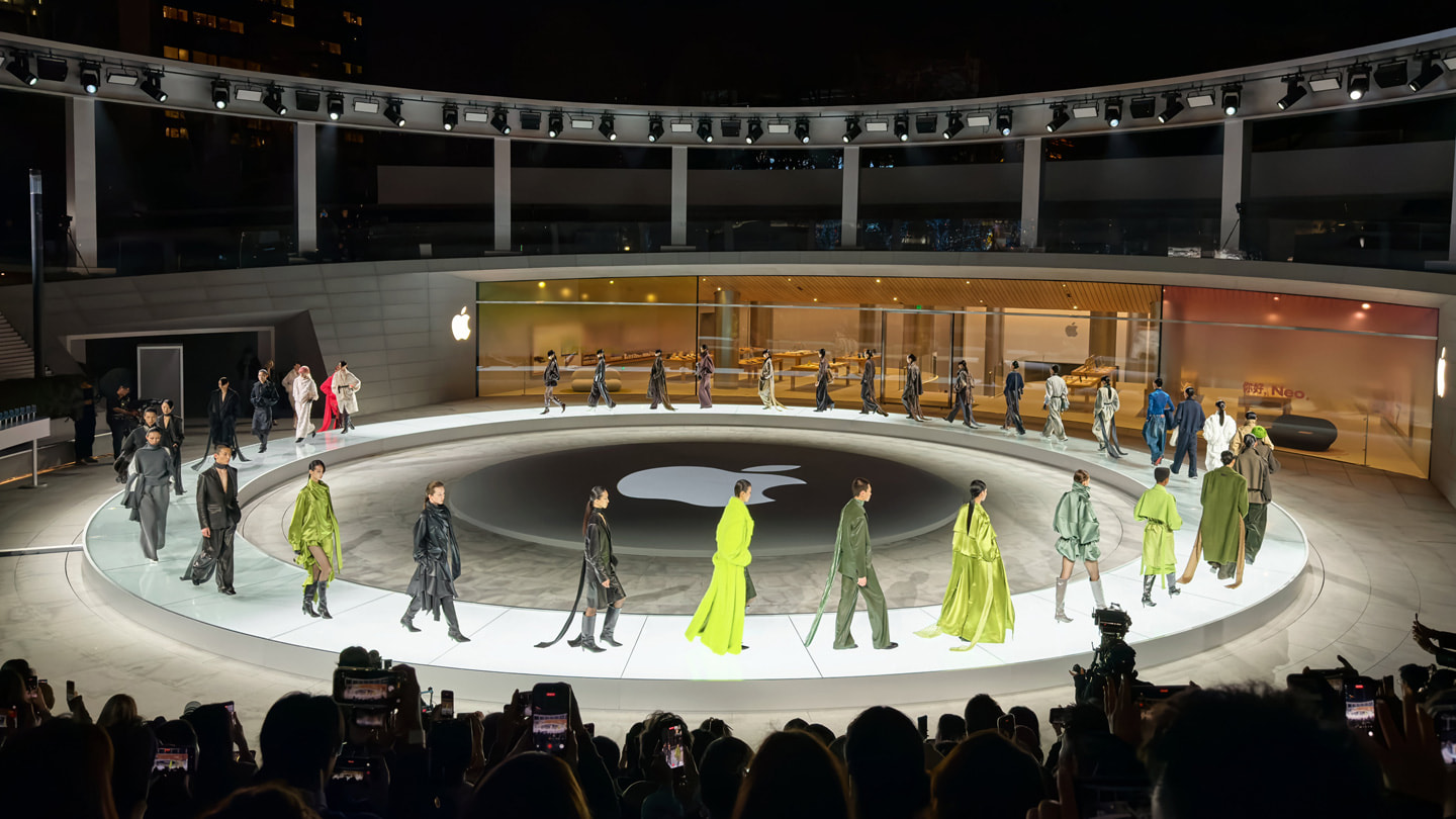 An overhead wide shot of three models walking a circular runway at Apple Jing’an.