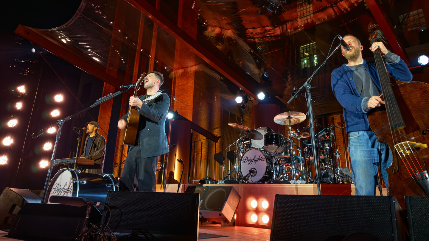 Members of the band Mumford & Sons are pictured performing on a stage outside of Apple Battersea in London.