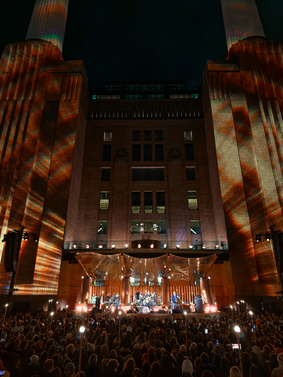 A view of the crowd at the Mumford & Sons performance showcases the Apple Battersea building in London.