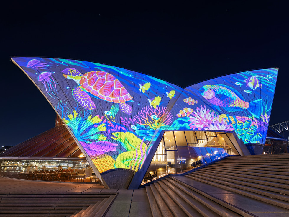 An artist’s Bennelong sails projection by Rebecca Mills shows a turtle swimming amid a colorful reef.