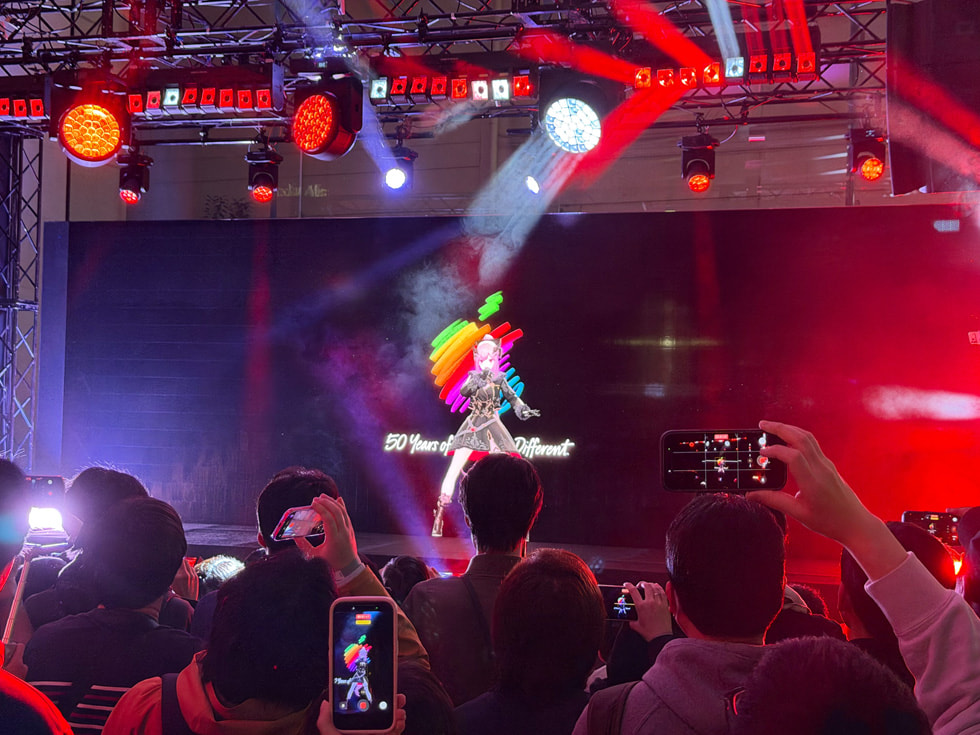 A view from the audience shows Mori Calliope performing on the stage at Apple Omotesando in Tokyo.