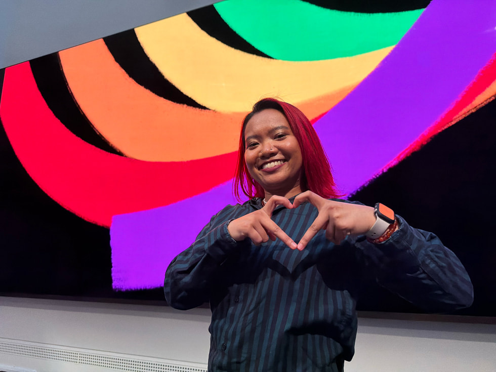 An attendee at the event at Apple Carnegie Library in Washington, D.C. makes a heart symbol with her hands and poses.