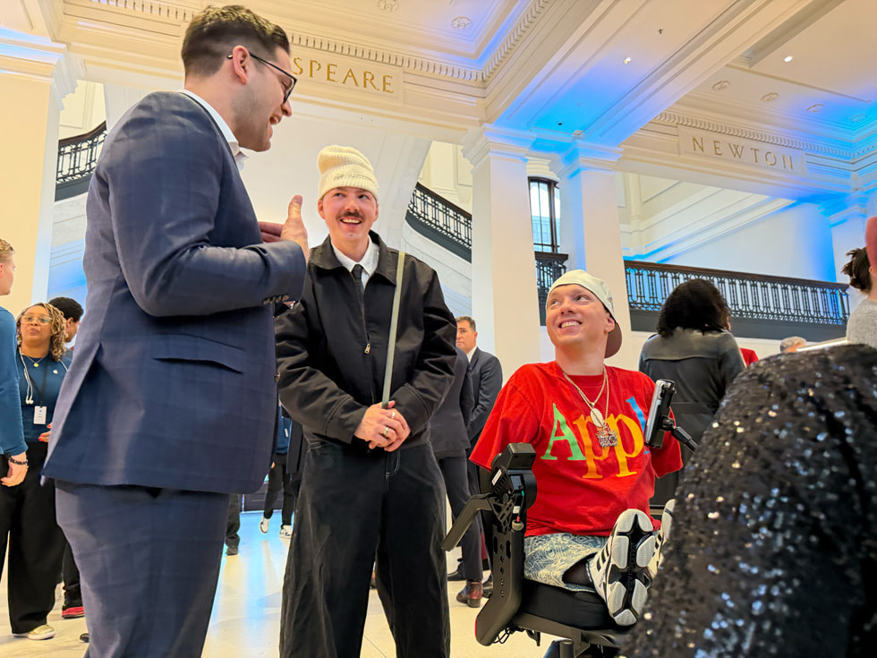 Attendees at the event at Apple Carnegie Library in Washington, D.C. are shown speaking with each other.