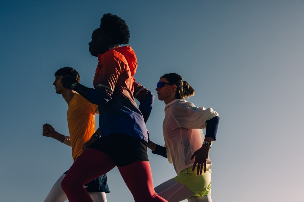 Three runners wearing Apple Watch devices are shown in profile.