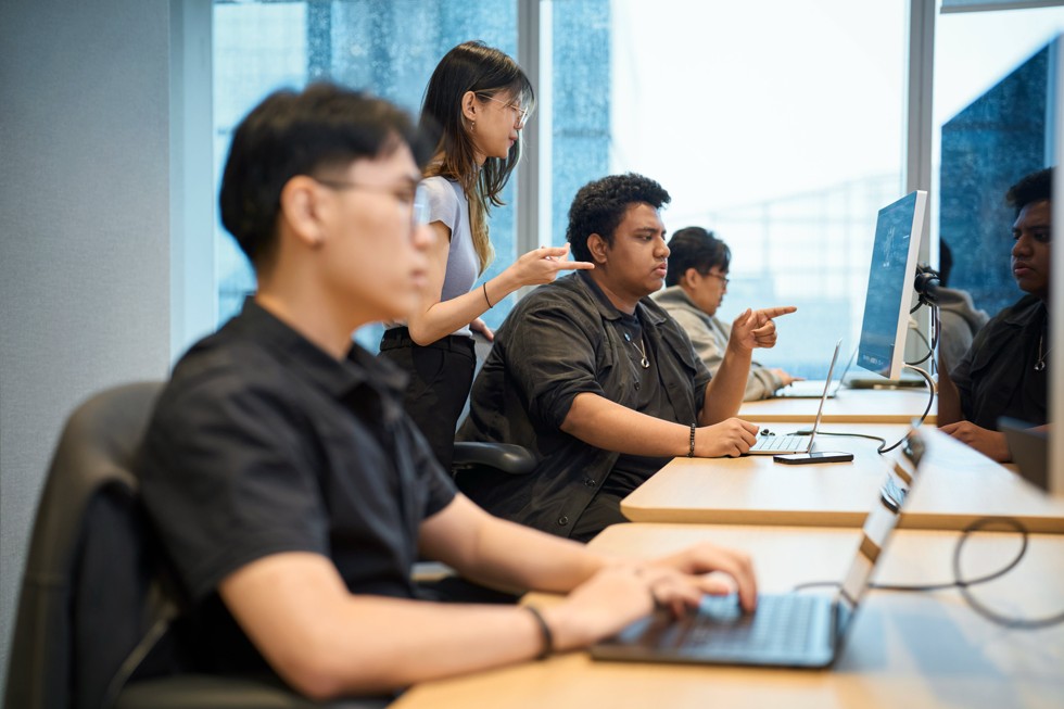 Peserta bekerja menggunakan perangkat MacBook di lingkungan kelas yang modern di Apple Developer Institute for Entrepreneurship di Indonesia.