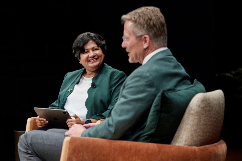 Priya Balasubramaniam y Kevin M. Guskiewicz mientras conversan sentados.