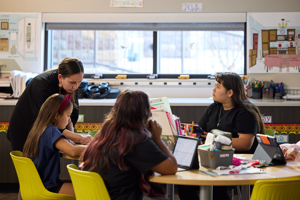 Minnia Whitener is pictured working with three students in a classroom at the Cherokee Immersion School in Tahlequah, Oklahoma.