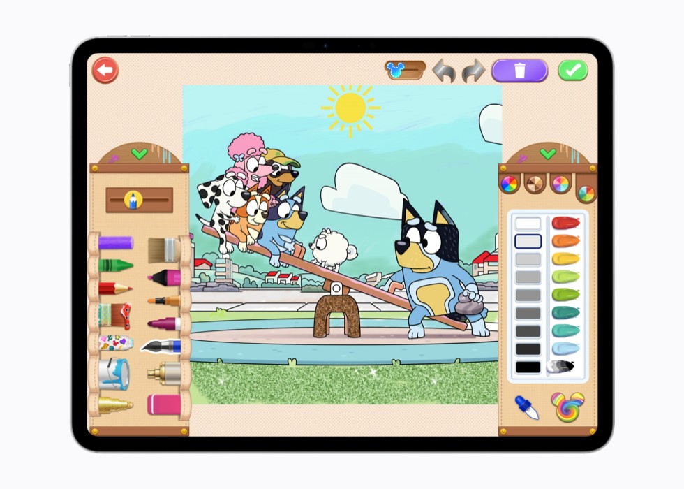 A still from Disney Coloring World+ on iPad shows a coloring page with two “Bluey” characters on a seesaw.