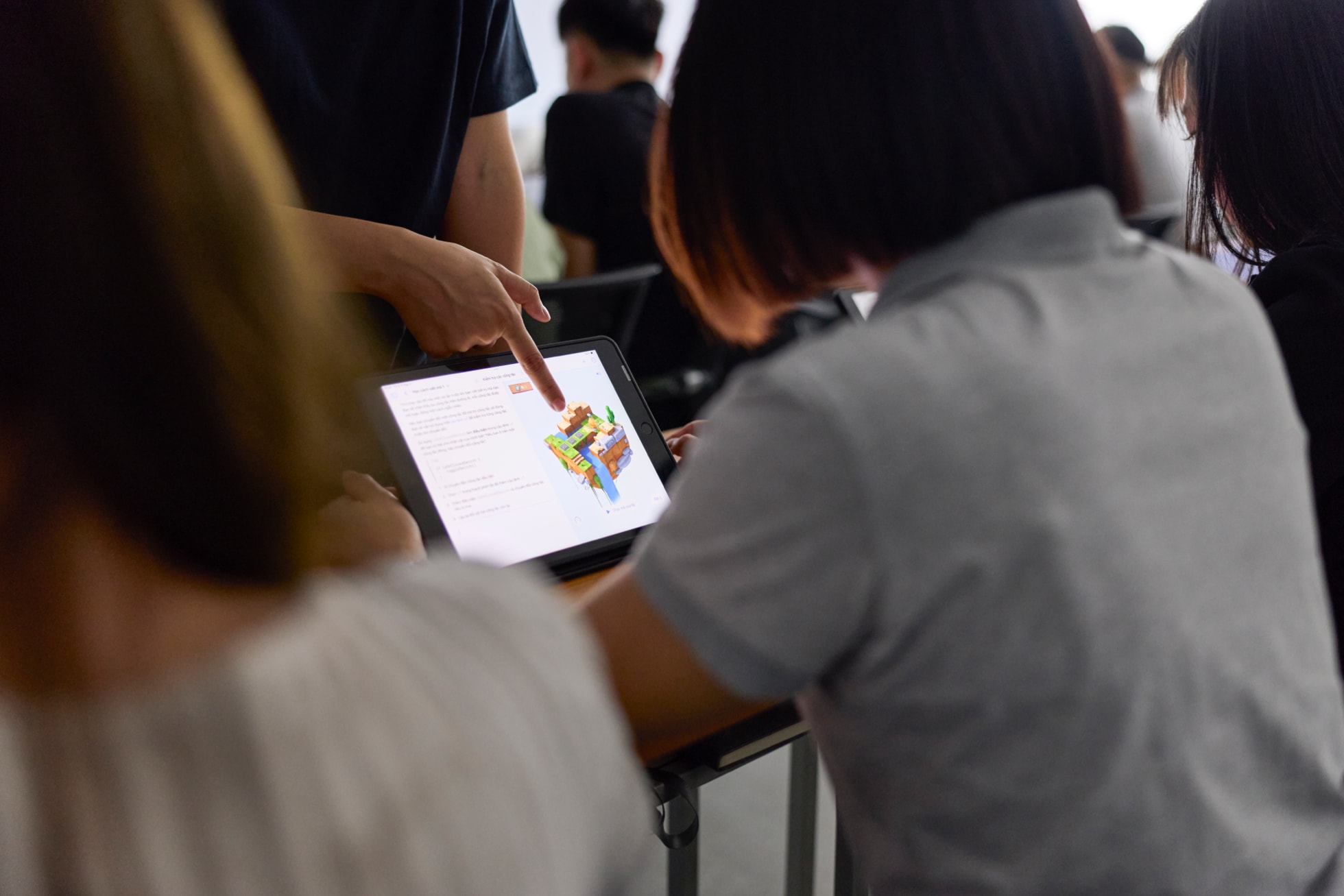 Hình ảnh một học viên đang được chỉ dẫn nội dung trên iPad.