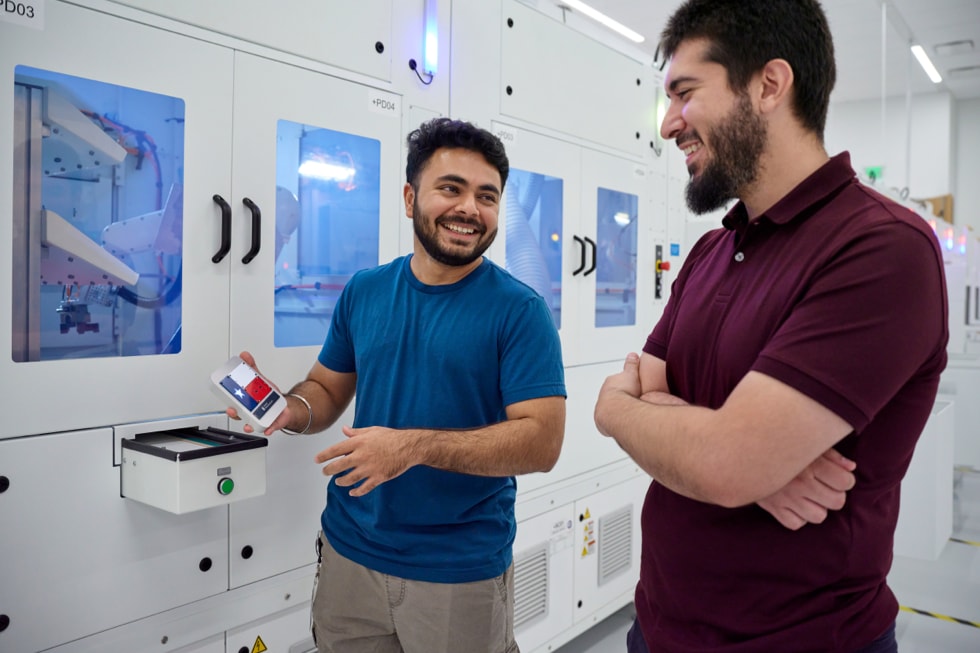 Two people are pictured near equipment at Apple’s Advanced Manufacturing Center in Houston.