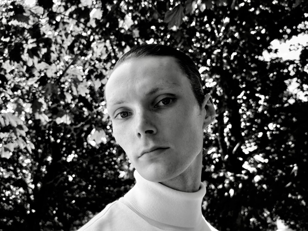 A black-and-white photograph of a person is captured on iPhone 18 Pro.
