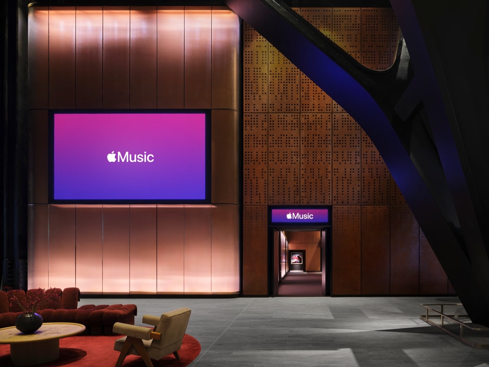 A comfortable foyer with a seating area and a large screen inside Apple Music Hall.