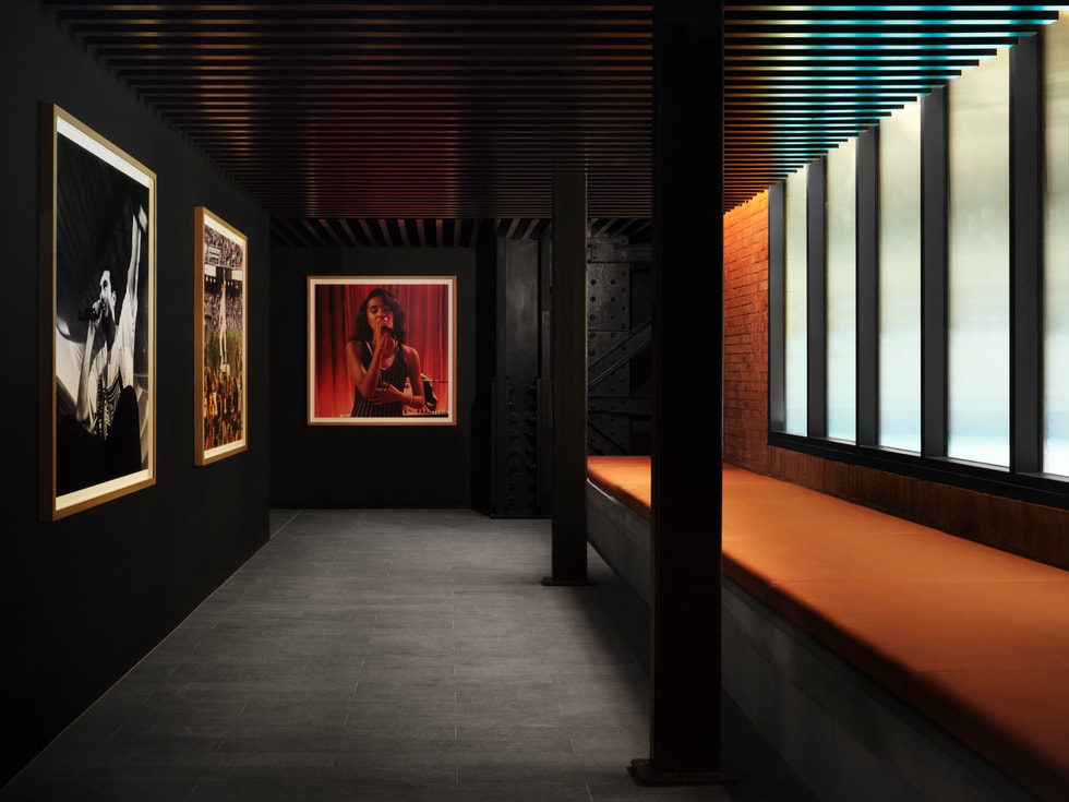 A hallway inside Apple Music Radio’s London studios, featuring posters of musicians and a frosted window.