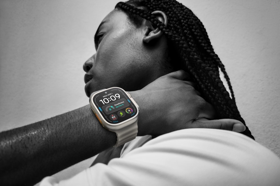 A black-and-white photo of a user wearing Apple Watch Ultra 4 with the actionable recommendation Go For It prominently displayed onscreen.