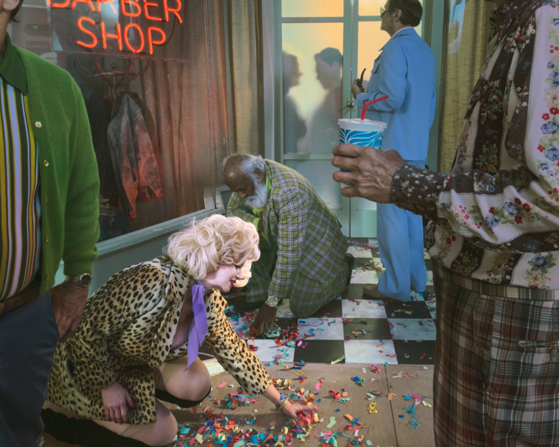 People in a barber shop are shown picking confetti off the ground.