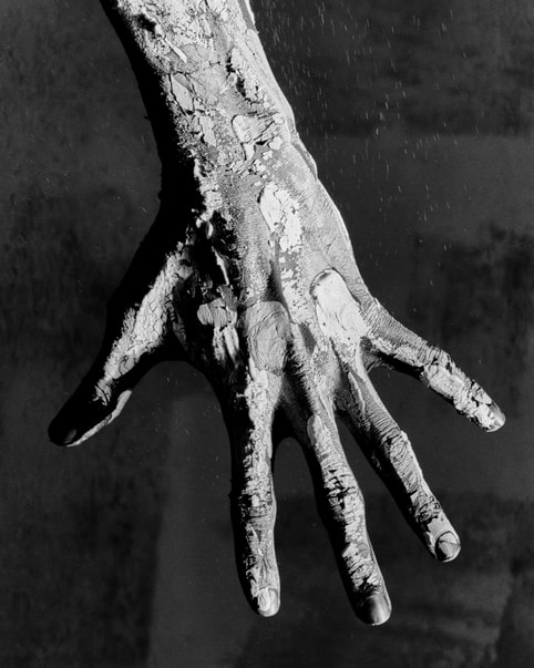 A hand covered in clay.